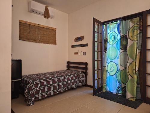 a bedroom with a bed and a stained glass window at Encantos da Ilha mais Bela - 150m das praias Viana e Siriúba in Ilhabela