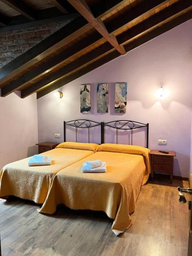 a bedroom with a bed with two pillows on it at Pensión El Campanu in Cangas de Onís