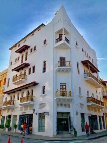 a large white building with balconies on a street at Soy Local Centro Histórico in Cartagena de Indias