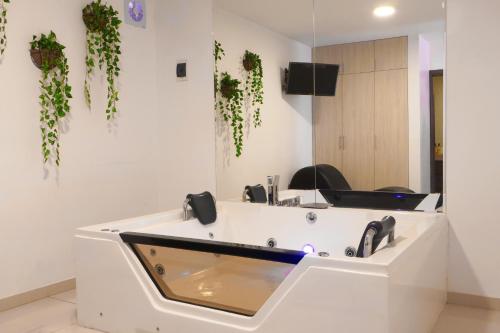 a white salon with plants on the wall at Rig Vêda Hotel in Lima