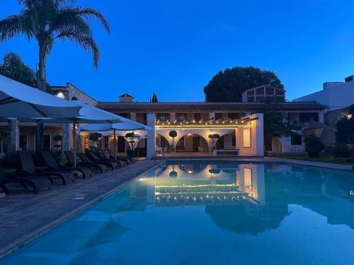 a house with a swimming pool at night at Hotel Maridelfi in Tequisquiapan