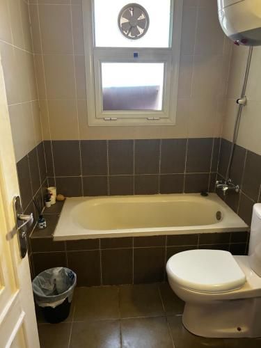 a bathroom with a tub and a toilet and a window at lavista cozy chalet one bedroom in Ain Sokhna