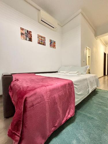 een slaapkamer met een bed met een rode deken erop bij The Palas Retreat in Iaşi