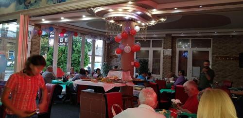a group of people sitting at tables in a restaurant at sobe za odmor in Petrovaradin