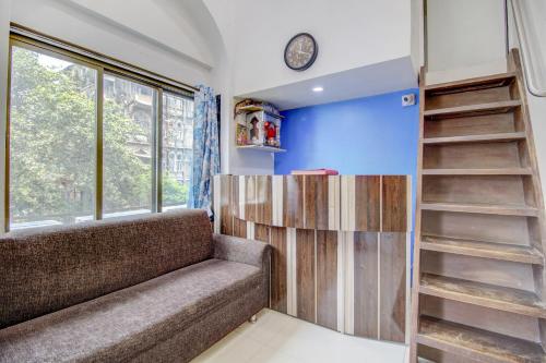a living room with a couch and a window at Hotel O Blue Light Near Gateway Of India Mumbai in Mumbai