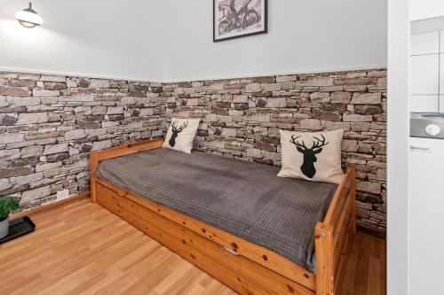 a bed in a room with a brick wall at Studio 2 pp - Crans-Montana Centre - Rue du Prado in Lens