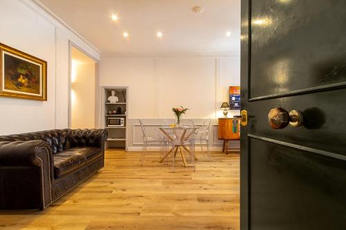 ein Wohnzimmer mit einer Ledercouch und einem Tisch in der Unterkunft Crispi 30 Stylish Apartment in Rom