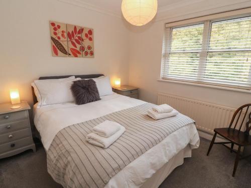a bedroom with a bed with towels on it at Riverside Cottage in Cockermouth