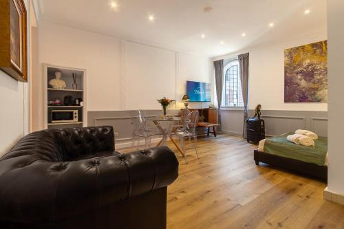 ein Wohnzimmer mit einer Ledercouch und einem Tisch in der Unterkunft Crispi 30 Stylish Apartment in Rom