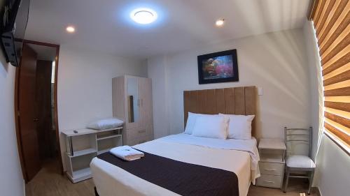 a small bedroom with a bed and a chair at Hotel Rosa Mistika Inn in Arequipa