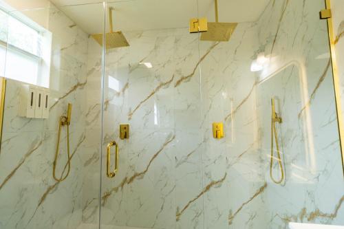 a bathroom with a shower with white marble walls at 10 Minutes from Universal - Relaxing Guest Suite in Orlando