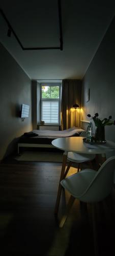 a bedroom with a bed and a table and a window at Mini Cozy Spot in Żagań