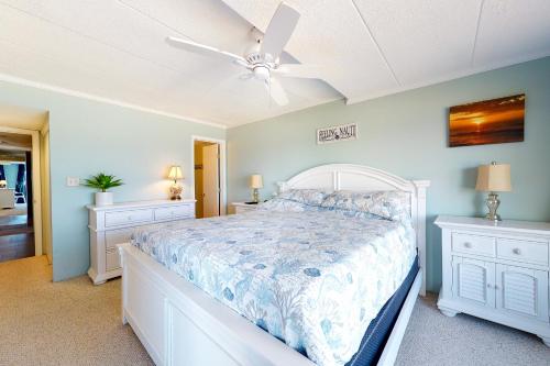 a bedroom with a white bed and a ceiling fan at Pelican Beach 304 in Ocean City