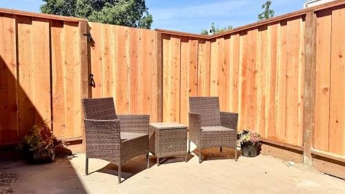 twee stoelen en een tafel voor een hek bij Remodeled Bungalow Suite with Parking, Steps from SJSU in San Jose