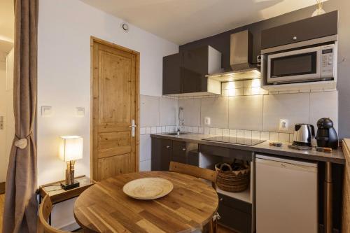 a kitchen with a wooden table in a kitchen at Le Cham' 106 - Happy Rentals in Chamonix-Mont-Blanc