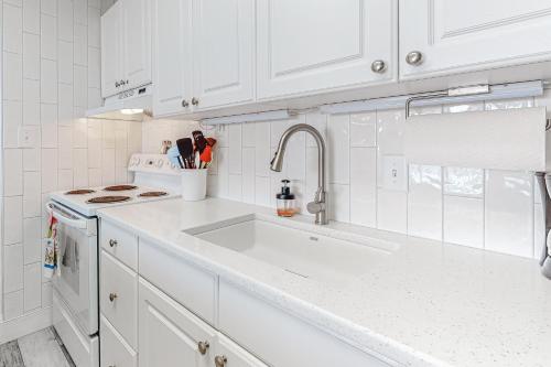 a white kitchen with a sink and a stove at Sails II 502 in Ocean City