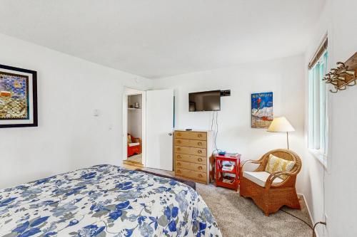 a bedroom with a bed and a chair and a dresser at Valley Gem Lower in Elkhorn Village