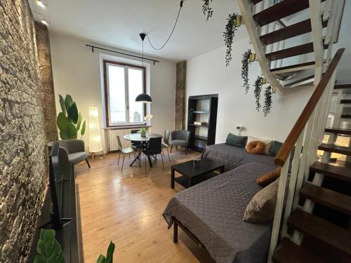 a living room with a bed and a dining room at The Loft in Pisa