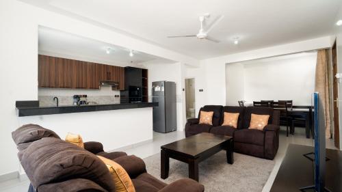 a living room with two couches and a kitchen at Marhaba Tausi Nyali in Mombasa