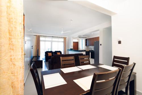 a dining room and living room with a table and chairs at Marhaba Tausi Nyali in Mombasa