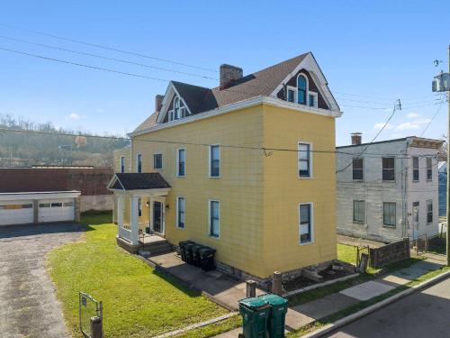 a large yellow house with a roof at Northside Suite 2 - Cozy Escape in Cincinnati