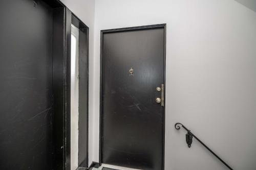 a black door in a white room with a chain at Northside Suite 2 - Cozy Escape in Cincinnati