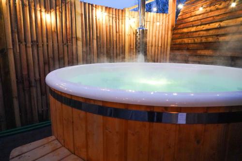 une baignoire dans une pièce avec un mur en bois dans l'établissement Homestead Gardens by Wigwam Holidays, à Filby