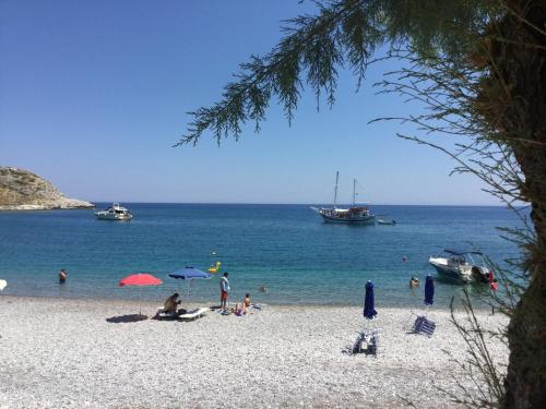 a group of people on a beach with boats in the water at Haraki Blue Pearl in Haraki