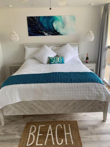 a bedroom with a bed with a beach sign on it at Chic Maui Condo Steps From Beach & Ocean in Wailea