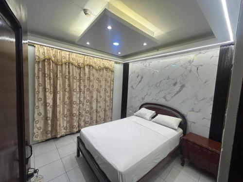 a bedroom with a bed and a stone wall at Hotel tower one in Guayaquil