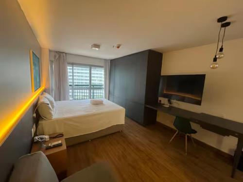 a bedroom with a bed and a desk and a television at Alugueasy - Hotel Fusion in Brasilia