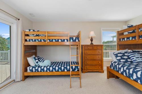 two bunk beds in a room with a window at Wahoo Waves in Emerald Isle