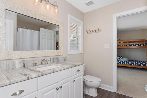 a bathroom with a sink and a toilet and a mirror at Wahoo Waves in Emerald Isle