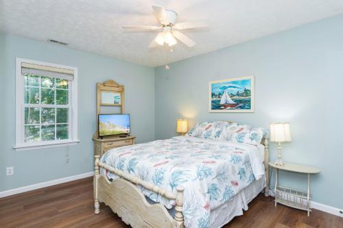 a bedroom with a bed and a ceiling fan at You, Me and The Sea in Cedar Point
