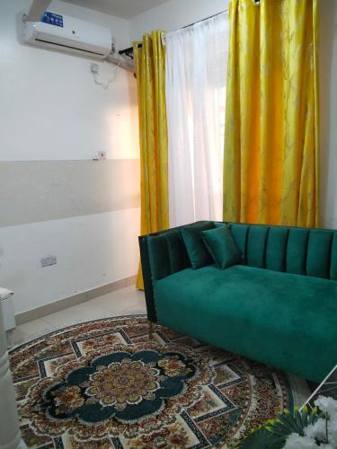 sala de estar con sofá verde y alfombra en Bnb, en Mombasa
