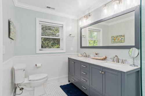 a bathroom with a sink and a toilet and a mirror at Sweet Dreams Beach House in Emerald Isle