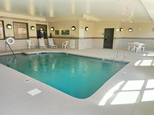 a large swimming pool with chairs and a table at Country Inn & Suites by Radisson, Concord (Kannapolis), NC in Concord