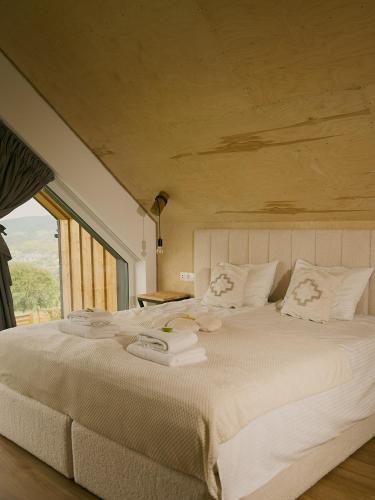a bedroom with a large white bed with a large window at Lipowe Apartmenty in Limanowa