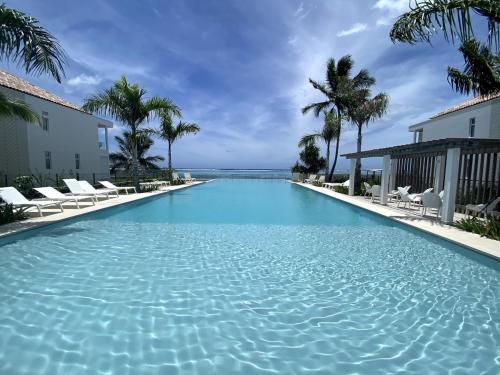 a swimming pool with palm trees and blue water at Tahiti Beach Loft - Pool - private beach access in Paea