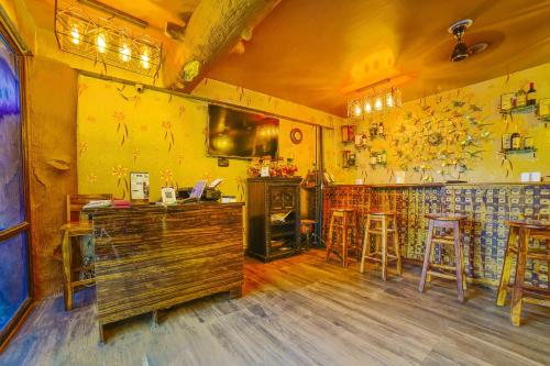 DānāpurにあるHotel O Cafe Garden Villaの黄色の壁と木の床のバーがあるレストラン