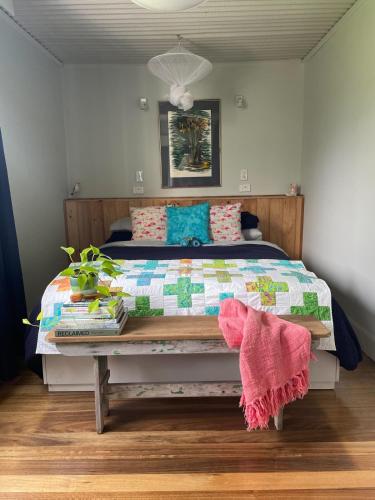 a bedroom with a bed with a quilt on it at The Orchard Guesthouse in Palmwoods