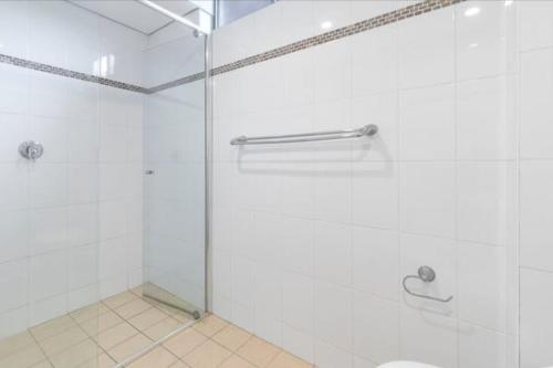 a bathroom with a shower with a glass door at Cosy Apartment close to Manly Beach in Sydney