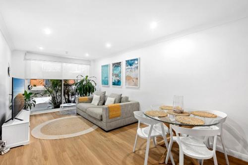 a living room with a couch and a table at Cosy Apartment close to Manly Beach in Sydney