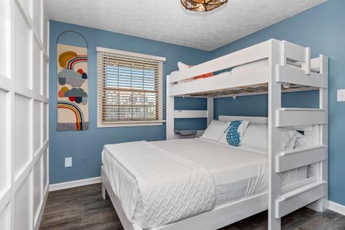a bedroom with a white bunk bed and blue walls at Ocean Reef 4 A-1 in Emerald Isle