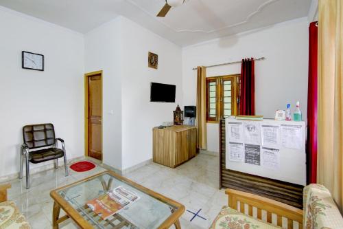a living room with a glass table and a tv at SPOT ON Chandra's Residence in Dehradun