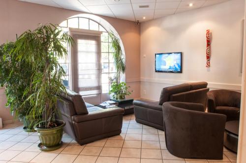 a waiting room with couches and a tv at Logis Hotel du Parc-Restaurant - Le Rouget de Lisle in Lons-le-Saunier
