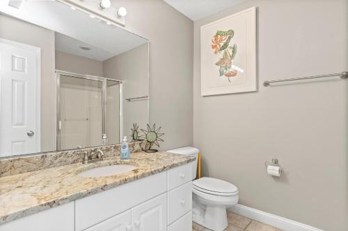a bathroom with a sink and a toilet and a mirror at Loving Life East in Emerald Isle