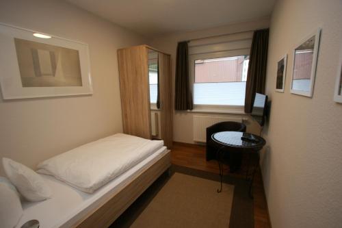 ein kleines Schlafzimmer mit einem Bett und einem Schreibtisch in der Unterkunft Ferienhaus Sonnenwinkel in Braunlage