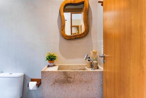 une salle de bain avec un lavabo et un miroir au mur dans l'établissement Apê Praia do Toque com Ar no Quarto e Sala, Condomínio com Academia, Quadra de Beach Tennis e Vôlei, Estacionamento Grátis e Restaurante, à São Miguel dos Milagres