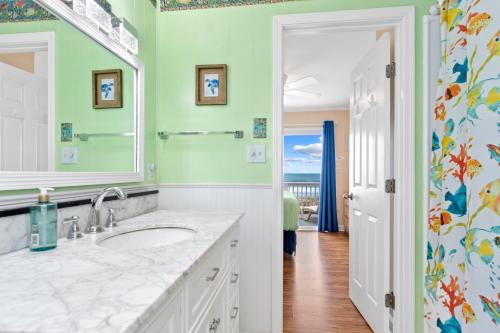 a bathroom with a sink and a mirror at Shady Shack West in Emerald Isle